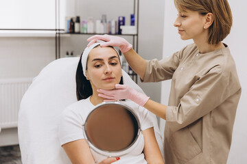 Beautician preparing woman for cosmetic injection in beauty salon