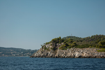 Naklejka premium Eine Insel im Meer. Felsen und Wälder. Blauer Himmel. Küste in Griechenland