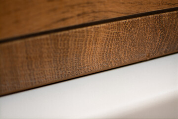 White bathroom meets wooden tile, brown silicone removed from the seam, showing an empty joint