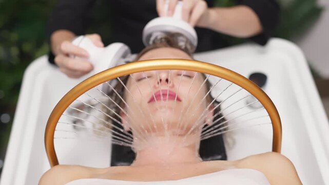 Woman receiving hydromassage head treatment in Japanese spa, relaxing in water with massager, surrounded by soothing ambiance and natural materials, promoting wellness and tranquility