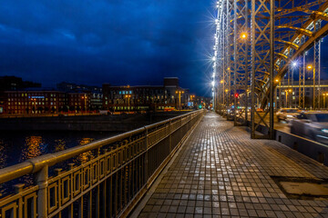 Long exposure night view of pedestrian walkway on Bolsheokhtinsky Bridge with illuminated riveted...