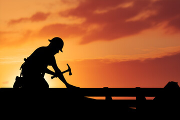 Silhouette of a Roofer Working on a House Roof Against a Sunset. Hard work and dedication concept for construction companies, real estate development, or career path marketing.