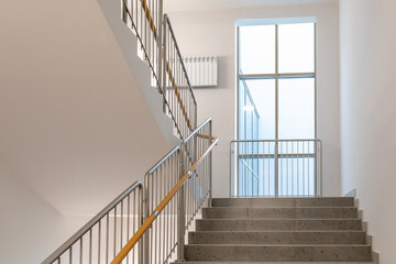 Staircase with metal railings and yellow handrail, modern interior. Minimal design staircase in...