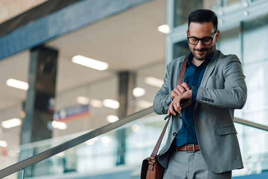 Businessman checking time on smartwatch in office