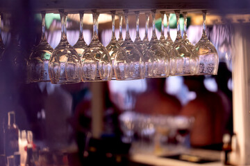 Close-up of clean wine glasses hanging in a bar