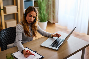 Customer service representative working from home providing support using laptop and documents