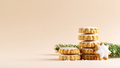 Festive cookies decorated with icing stacked beside pine branches during holiday season