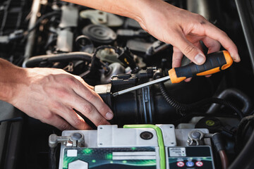 Mechanic repairs engine components in workshop during daytime to ensure vehicle performance and...
