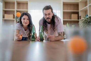 Fototapeta premium Couple playing beer pong at home, throwing ping pong balls