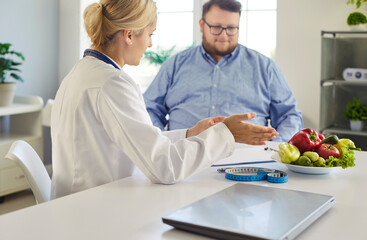 Nutritionist doctor advises fat overweight man patient on obesity diet during consultation in a...