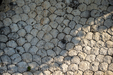 Natural stone wall texture background. Close-up of a traditional rock wall with a repeating fish...