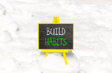 Build habits symbol. Concept word Build habits on beautiful black blackboard. Beautiful white snow...