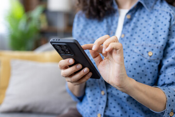 Woman using smartphone on sofa: browsing internet and social media