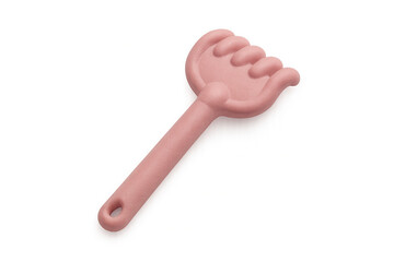 Pink plastic rake resting on transparent surface, ideal for sandbox play and outdoor activities