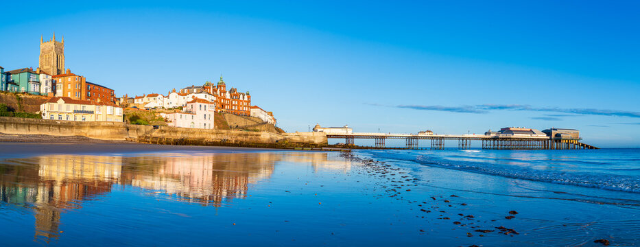 A panoramic view of Cromer town with the Victorian pier and Parish Church with sunrise light