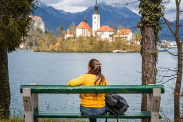 Mujer viajera sentada en un banco en la rivera del lago Bled, en Eslovenia © Javier