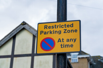 Uk road sign indicating a restricted parking zone and there is no parking at any time
