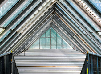 Triangular glass and steel roof frames repeat in symmetry with daylight entering the interior of Palma de Mallorca PMI airport terminal architecture