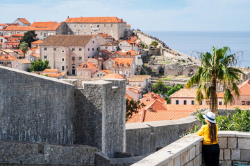 Mujer viajera con sombrero contemplando las vistas de la ciudad de Dubrovnik desde un mirador