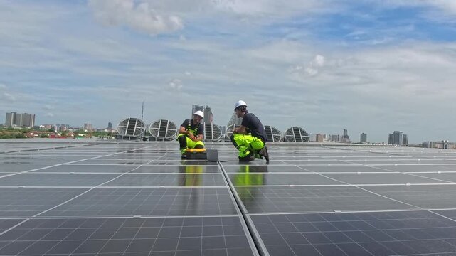 Two technicians carefully install solar panels on a rooftop in an urban location. They check the alignment and fix the panels to ensure optimal performance in bright sunlight.