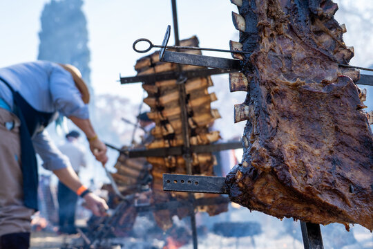 Asado de costillares a las brazas estilo Argentino siendo cocinado por un Gaucho