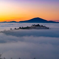 Obraz premium Misty mountain sunrise over a valley