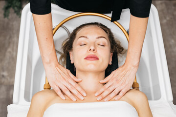 Asian woman receiving a soothing head massage during a traditional Japanese spa treatment, with...