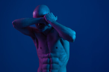 A striking image of a man posing dramatically with his arms covering his eyes, featuring a vibrant blue color palette, creating a captivating and emotive atmosphere.
