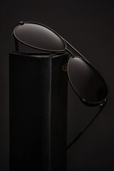 Stylish aviator sunglasses on dark background