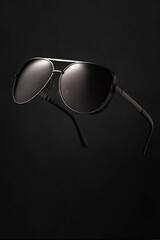 Stylish aviator sunglasses on dark background