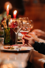 Elegant dinner moment with wine glass held during candlelit celebration or gourmet event