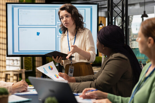 Collaborative team of professional women reviews key data and reports while setting strategy for business growth, aligning insights with development goals and teamwork. Networking.