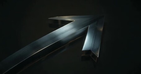 Spinning metallic arrow turning slowly after sequence start in studio, revealing beveled edges - Powered by Adobe