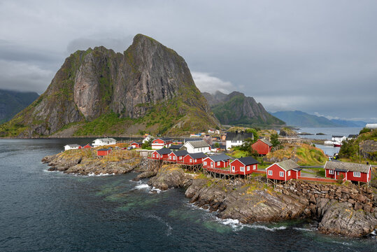 Red tourist cabins nestled among mountains in Hamnoy fishing village on Lofoten Islands, Norway