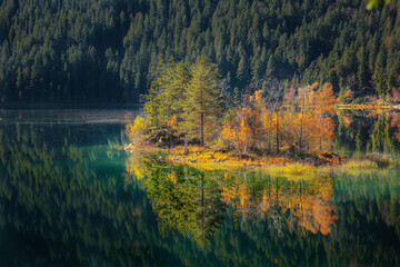 Amazing autumn  landscape of islands with pine-trees in the middle of Eibsee lake.