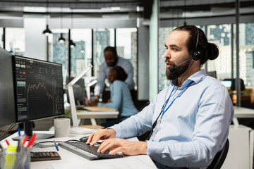 Trader working for brokerage company talking with clients, explaining stock market trends through headset mic. Man analyzing market options and recommends tailored investment strategies for customers
