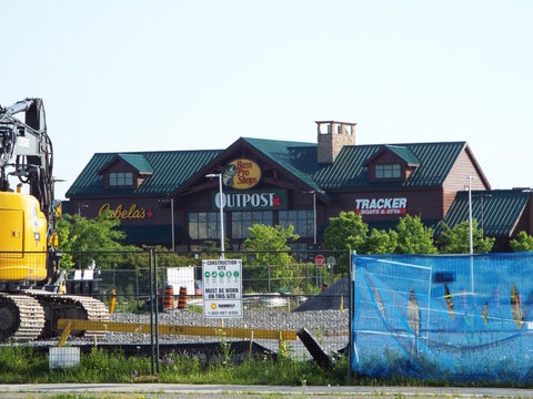 Kanata, ON, Canada, June 15, 2025:A large, rustic-style building  housing three different businesses: Cabela's, Bass Pro Shops Outpost, and Tracker Boats  and ATVs at 3065 Palladium Dr.