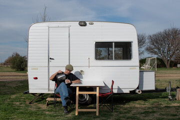 Mujer mayor disfrutando el exterior del trailer sentada cebando mate © Patricia Molaioli