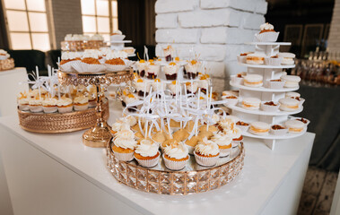 Luxurious wedding dessert table with cupcakes, macarons, and creamy mini treats
