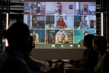 Diverse coworkers joining a video conference with international stakeholders, gathering in...