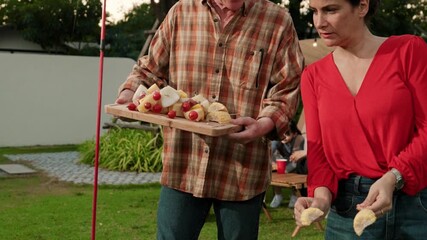 Family all together camp in garden, Old couple cooking BBQ, having a meal. Senior use outdoor camping activity, relax with nature and spend time with young generation cross generation gap. Divergence.