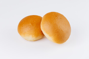 Two fresh golden hamburger buns on white background, ideal for bakery or food packaging design