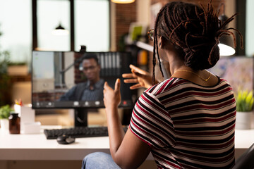 Black woman uses desktop pc for virtual meeting, discussing marketing strategies with business...