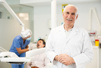 Obraz premium Elderly male doctor dentist during examination of patient in office