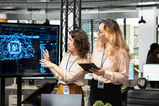 Team of coworkers using strategic artificial intelligence cloud computing to conduct data analysis, optimized decision making and project forecasting. Development with AI automation.