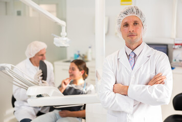 Fototapeta premium Adult male nurse during examination of female patient in dental office