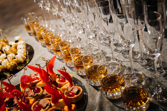 Elegant buffet with whiskey shots, canapes, and champagne glasses at a luxury event