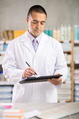 Male seller makes notes on electronic tablet - keeps track of the receipt and expenditure of...
