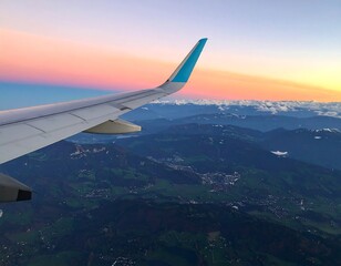 Fototapeta premium Airplane wing over mountain range at sunset
