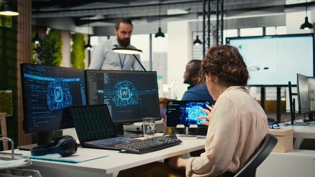 Office administrator checking monthly reports with AI analytics platform, employing neural networks algorithms and automation for business productivity. IT company representative at work.